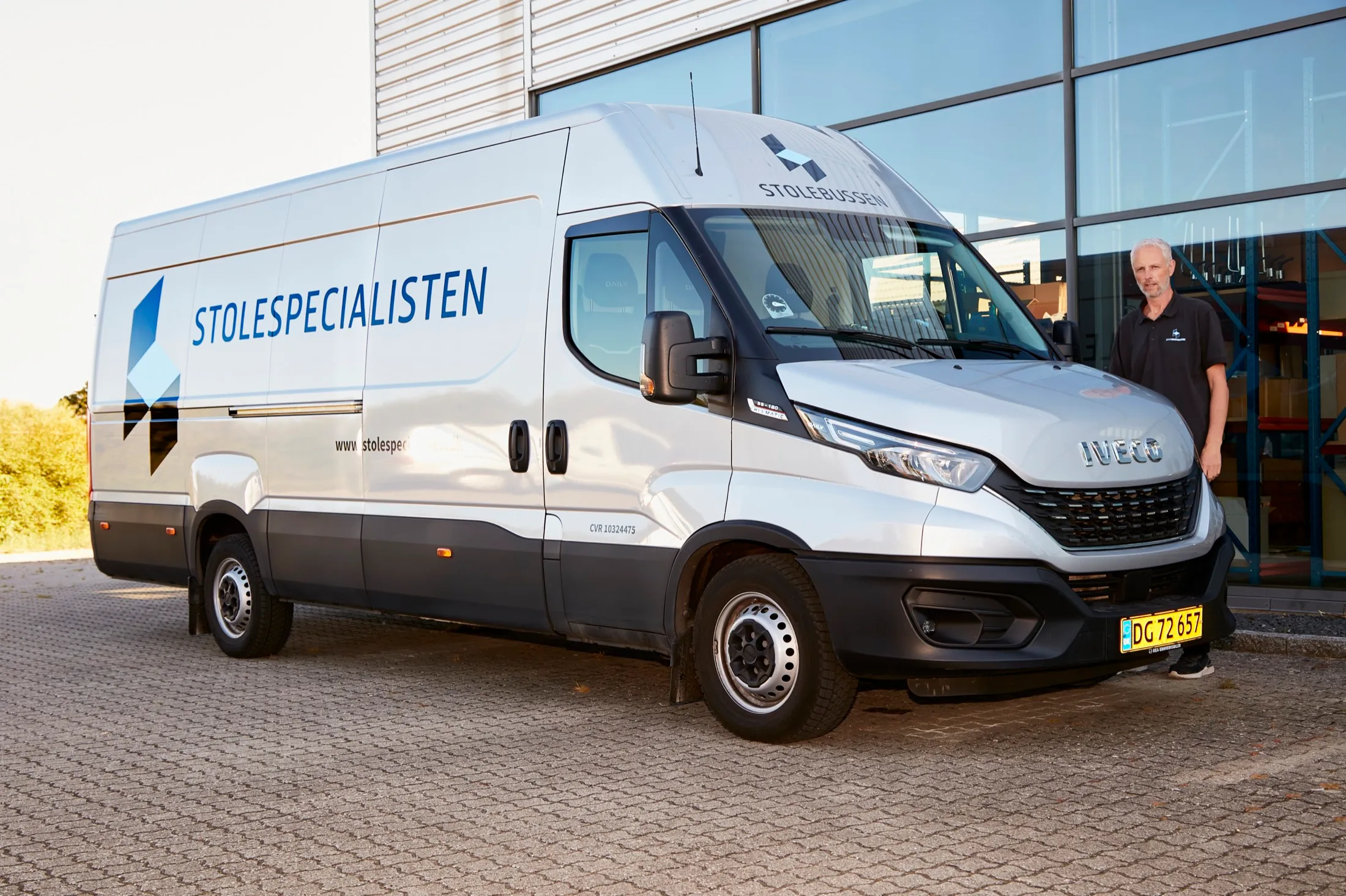 Stolebussen med chauffør foran showroom